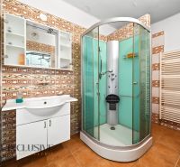 Badezimmer in einem Einfamilienhaus mit Duschkabine und Keramikfliesen.