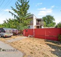 Ein Einfamilienhaus in Bodza mit Garten, Auto und Anhänger an der Straße.
