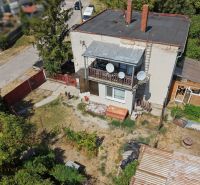 Ein Einfamilienhaus in Bodza mit zwei Schornsteinen, einer Terrasse und einem weitläufigen Garten mit Bäumen.