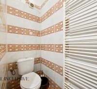 Toilette mit Fliesen im Einfamilienhaus, weiße Heizung, gemusterte Fliesen.