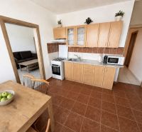 Küche in einer 3-Zimmer-Wohnung mit Holzelementen und Esstisch.