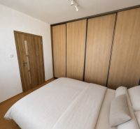 Das Innere eines Schlafzimmers in einer 3-Zimmer-Wohnung mit Holzboden und einem großen Schrank.