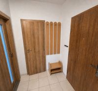 Innenraum einer 3-Zimmer-Wohnung mit Holztüren und Fliesen.