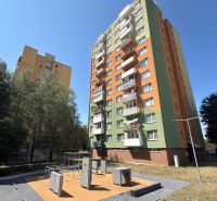 Ein Hochhaus mit grün-orangefarbener Fassade und Spielplatz in Senica bietet eine 3-Zimmer-Wohnung an.