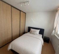 Schlafzimmer in einer 3-Zimmer-Wohnung mit Bett, Einbauschrank und Fenster.