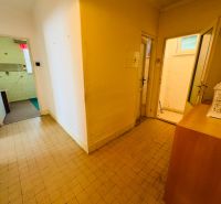 Der Flur einer 2-Zimmer-Wohnung mit Fliesen und mehreren offenen Türen.