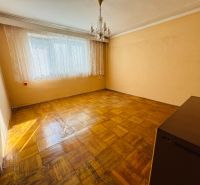 Ein Zimmer in einer 2-Zimmer-Wohnung mit einem Kristallleuchter und einem Boden in Holzoptik.