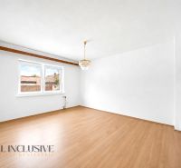 Einfamilienhaus mit Holzboden und Kronleuchter, weiße Wände, großes Fenster.
