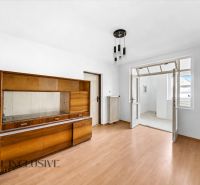 Ein Zimmer in einem Einfamilienhaus mit einem Holzboden und älteren Möbeln.