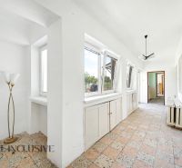Flur in einem Einfamilienhaus mit großen Fenstern, Fliesenboden und Leuchte.
