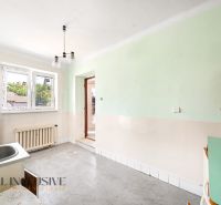 Küchenbereich in einem Einfamilienhaus mit Spüle, grünen Wänden und Heizkörper.