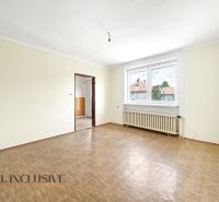Geräumiger Raum mit Holzboden und großem Fenster in einem Einfamilienhaus.