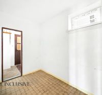 Ein Zimmer in einem Einfamilienhaus mit gefliestem Boden und weißen Wänden.