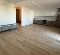 Küchenbereich einer 3-Zimmer-Wohnung mit Holzboden und weißen Schränken.
