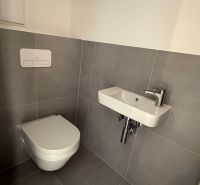 Kleines Badezimmer in einer 3-Zimmer-Wohnung mit Toilette und Waschbecken.