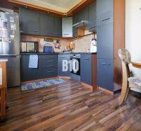 Küche in einer 2-Zimmer-Wohnung mit Holzboden und dunklen Möbeln.