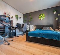 Schlafzimmer einer 3-Zimmer-Wohnung mit stilvoller Dekoration und Holzboden.