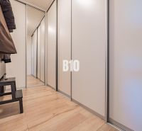 Der Flur in einer 3-Zimmer-Wohnung mit Stauraum und einem Boden in Holzoptik.