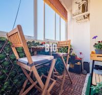 Verglaste Balkonterrasse mit Holzboden und Pflanzen in einer 3-Zimmer-Wohnung.