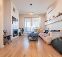 Wohnzimmer in einer 3-Zimmer-Wohnung mit Holzboden, Sofa und Kamin.