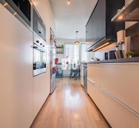Küche in einer 3-Zimmer-Wohnung mit Holzboden und Geräten.