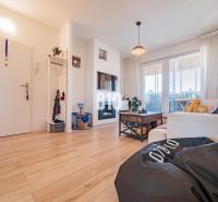 Wohnzimmer in einer 3-Zimmer-Wohnung mit Holzboden und bequemen Sitzgelegenheiten.