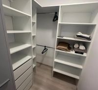 Stauraum mit Regalen, Schubladen und einem Boden mit Holzdekor in einer 2-Zimmer-Wohnung.