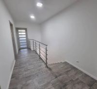 Flur in einem Einfamilienhaus mit Treppe und Keramikfliesen.