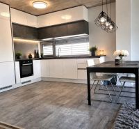 Küche und Essbereich in einem Einfamilienhaus mit Holzdekorboden.
