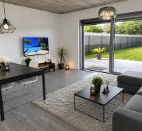 Wohnzimmer in einem Einfamilienhaus mit Holzboden und Blick in den Garten.