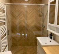 Badezimmer mit Duschkabine und Boden in Holzoptik in einer 3-Zimmer-Wohnung.