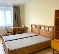 Schlafzimmer mit Holzbett, Tisch und Boden mit Holzdekor in einer 3-Zimmer-Wohnung.