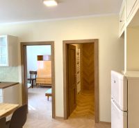 Innenraum einer 3-Zimmer-Wohnung mit Holzboden, Stühlen und Einbauschrank.