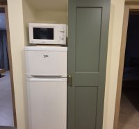 Mikrowelle und Kühlschrank in der Küche einer 3-Zimmer-Wohnung mit Holzboden.