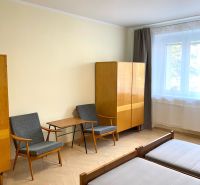 Ein Zimmer in einer 3-Zimmer-Wohnung mit einem Holzboden, zwei Sesseln und einem Schrank.