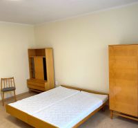 Schlafzimmer mit Bett, Schrank und Holzboden in einer 3-Zimmer-Wohnung.