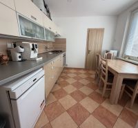 Küche in einer 3-Zimmer-Wohnung mit Esstisch, Küchenzeile und Geräten.