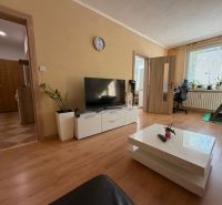 Wohnzimmer in einer 3-Zimmer-Wohnung mit Holzboden, Fernseher und Laufband.