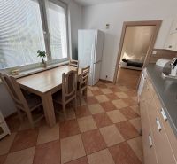 Küche in einer 3-Zimmer-Wohnung mit Fliesenboden, Esstisch und Geräten.