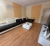 Wohnzimmer mit Sofa, Fernseher und Holzboden in einer 3-Zimmer-Wohnung.