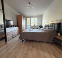 Schlafzimmer in einer 3-Zimmer-Wohnung mit Bett, Kleiderschrank und Holzboden.
