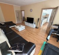 Wohnzimmer in einer 3-Zimmer-Wohnung mit Holzboden und Ledersofa.