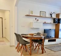 Essbereich mit vier Stühlen und Fernseher in einer 3-Zimmer-Wohnung.