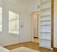 Innenraum einer 3-Zimmer-Wohnung mit Regal und Boden in Holzoptik.