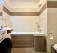 Badezimmer in einer 3-Zimmer-Wohnung mit Badewanne, Waschmaschine und Toilette.