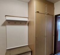 Einbauschrank und Garderobenwand mit Bank in einer Einzimmerwohnung.