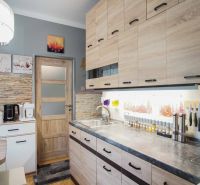 Küche in einer 2-Zimmer-Wohnung mit Holzboden und hellen Möbeln.