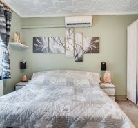 Schlafzimmer in einer 2-Zimmer-Wohnung mit Klimaanlage und abstrakten Bildern an der Wand.