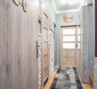 Ein schmaler Flur einer 2-Zimmer-Wohnung mit Holzelementen und Einrichtung.