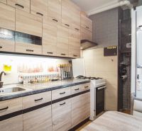 Küche in einer 2-Zimmer-Wohnung mit Holzboden und Geräten.